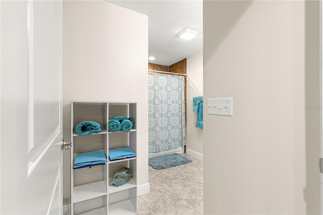 bathroom with a textured ceiling and a shower with shower curtain