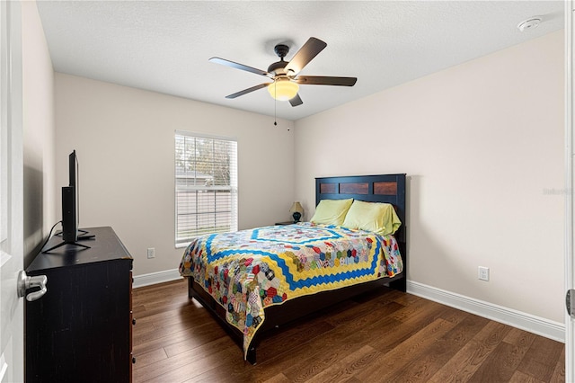 bedroom with a textured ceiling, dark hardwood / wood-style floors, and ceiling fan