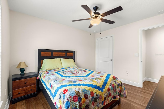 bedroom with dark hardwood / wood-style flooring and ceiling fan