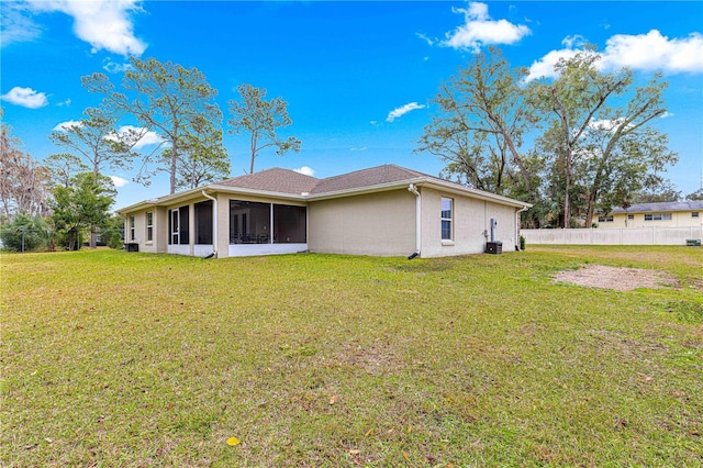 back of house with a sunroom and a lawn