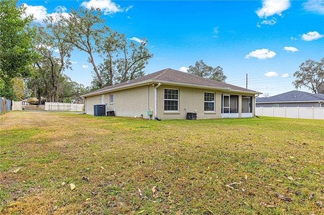 back of property with a yard and central AC unit