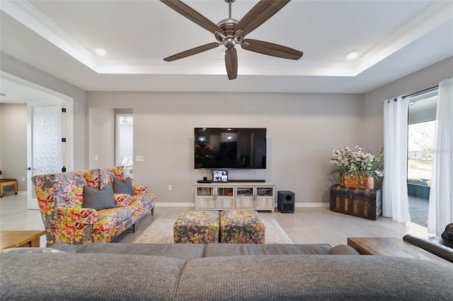 tiled living room featuring crown molding, a raised ceiling, and ceiling fan