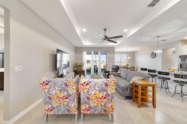 living room featuring french doors, ceiling fan, ornamental molding, and a tray ceiling