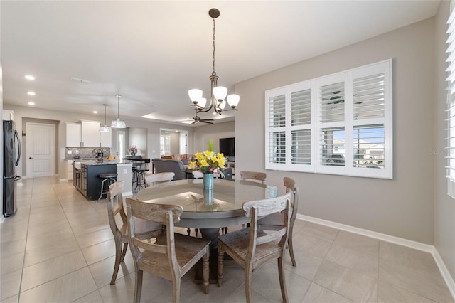 dining room with sink, light tile patterned floors, and a notable chandelier