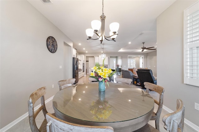 dining room featuring ceiling fan with notable chandelier