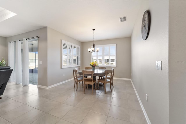 tiled dining area featuring a chandelier