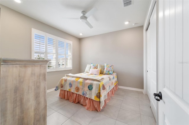 bedroom with a closet, ceiling fan, and light tile patterned flooring