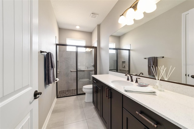 bathroom featuring vanity, toilet, an enclosed shower, and tile patterned flooring