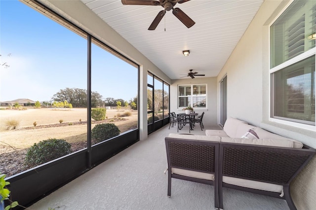 sunroom / solarium featuring ceiling fan