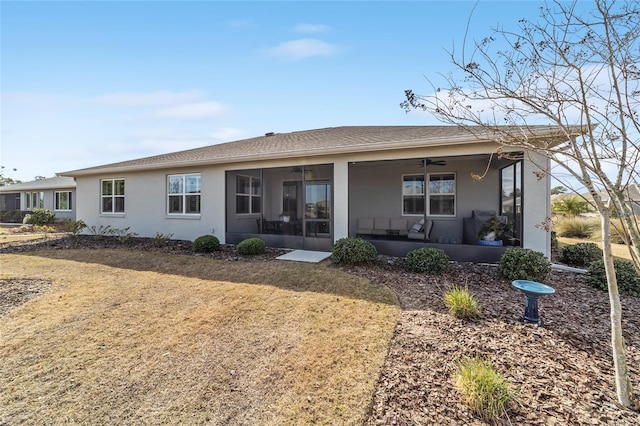 rear view of property featuring a yard, a sunroom, and ceiling fan