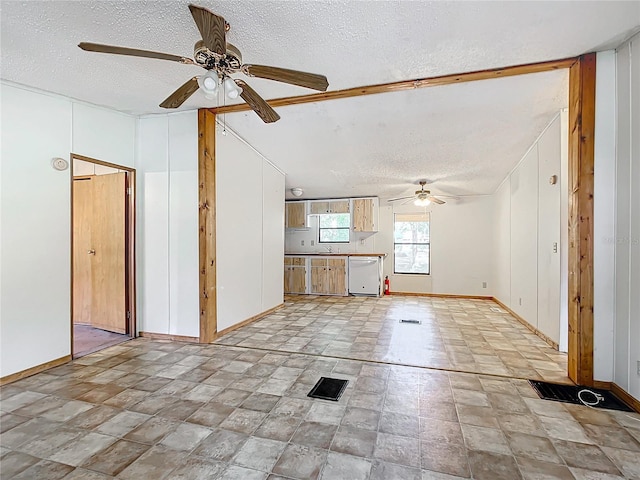 unfurnished living room featuring ceiling fan, sink, and a textured ceiling