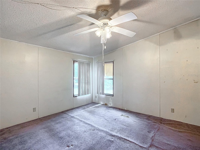 carpeted empty room featuring ceiling fan and a textured ceiling