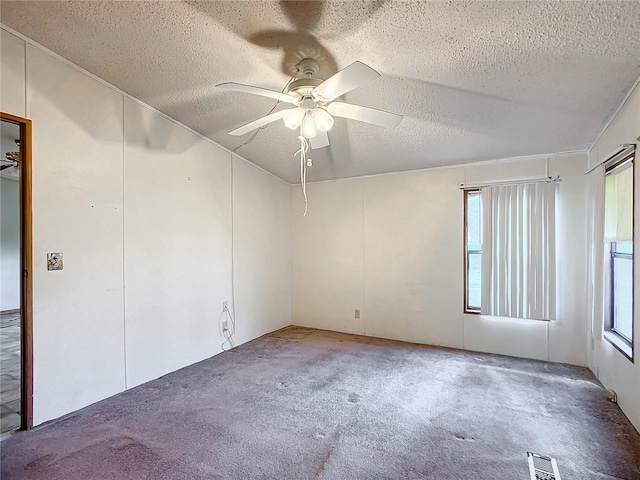 carpeted spare room featuring ceiling fan and a textured ceiling