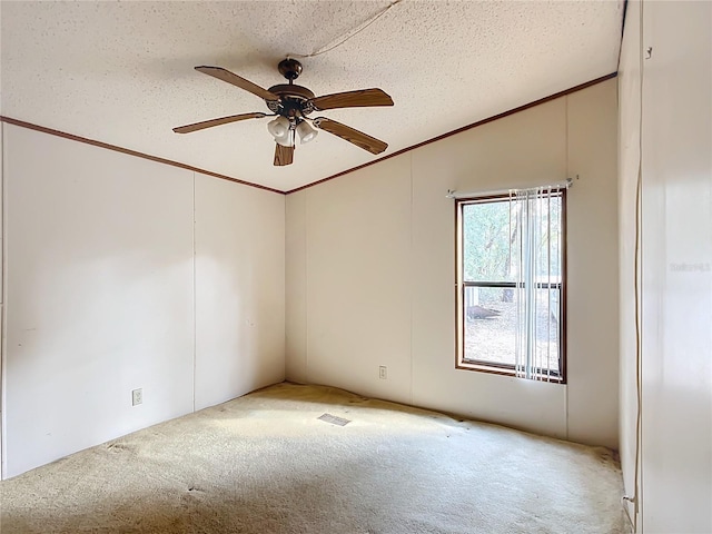 carpeted spare room featuring crown molding, ceiling fan, vaulted ceiling, and a textured ceiling