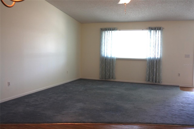 carpeted empty room featuring a textured ceiling