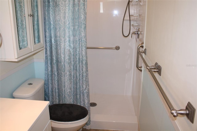 bathroom with walk in shower, vanity, and toilet