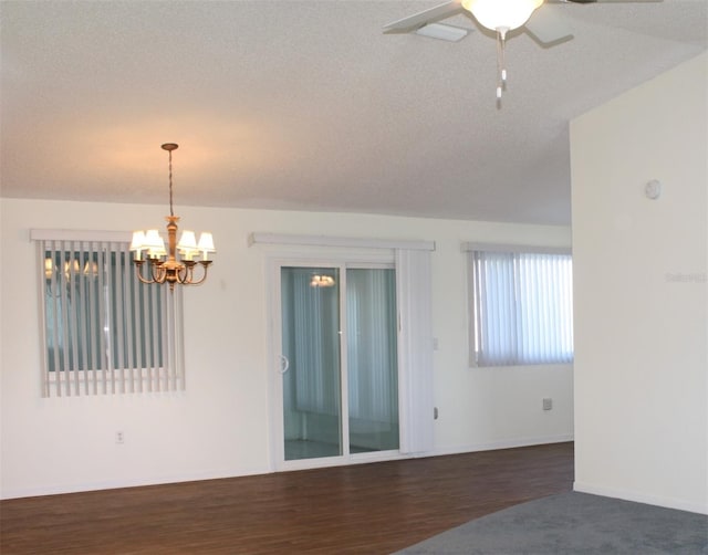 empty room with dark hardwood / wood-style floors, ceiling fan with notable chandelier, and a textured ceiling