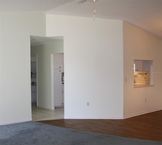 carpeted empty room featuring lofted ceiling and ceiling fan