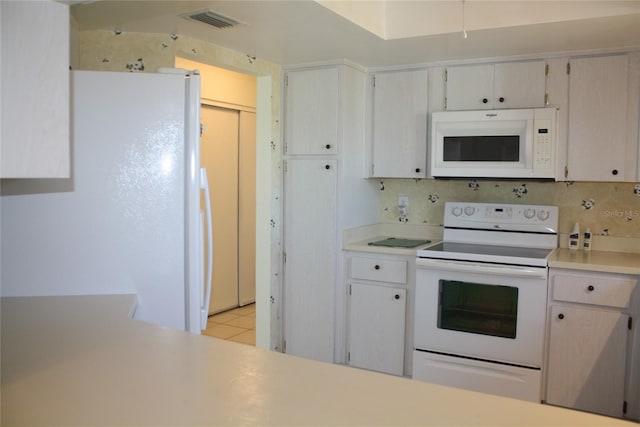 kitchen featuring light tile patterned flooring, white appliances, and decorative backsplash