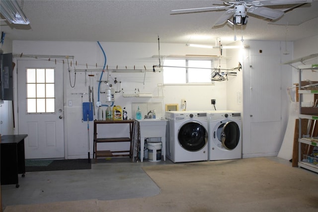 laundry area with a healthy amount of sunlight, washing machine and clothes dryer, a textured ceiling, and electric panel