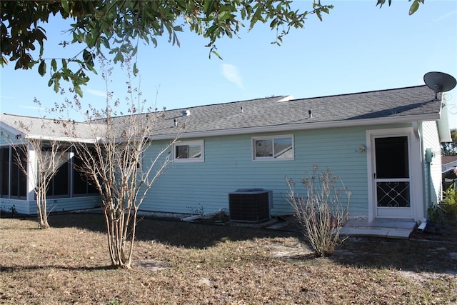 back of property featuring cooling unit and a yard