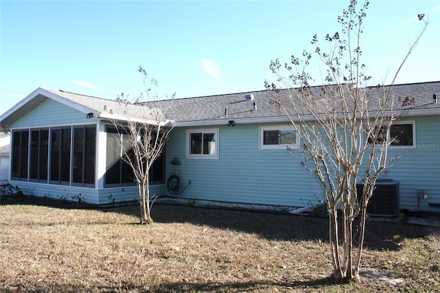 rear view of property with cooling unit, a yard, and a sunroom