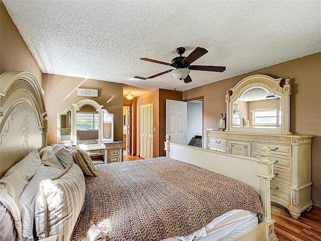 bedroom with light wood-style flooring, multiple windows, and a textured ceiling