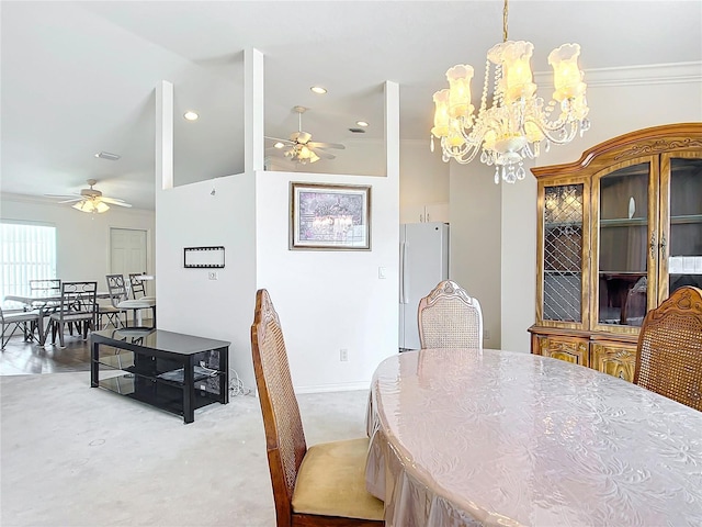 dining area with carpet floors, crown molding, and ceiling fan with notable chandelier