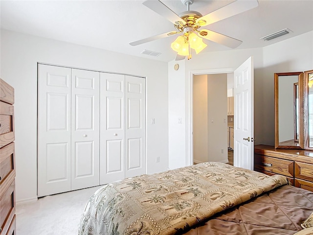 bedroom featuring light colored carpet, ceiling fan, and a closet