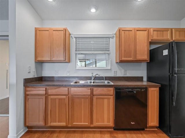 kitchen featuring sink, black appliances, and light wood-type flooring