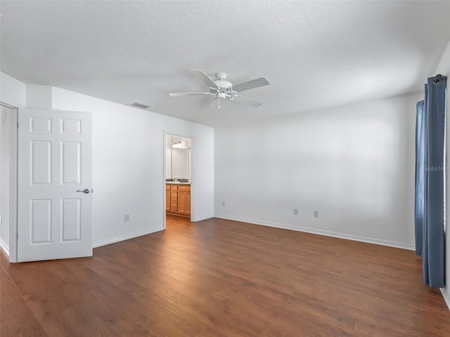 spare room with dark hardwood / wood-style flooring, a textured ceiling, and ceiling fan