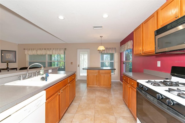 kitchen with sink, white appliances, a center island, light tile patterned flooring, and decorative light fixtures