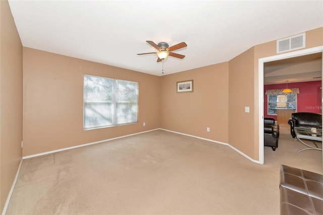 carpeted spare room featuring ceiling fan