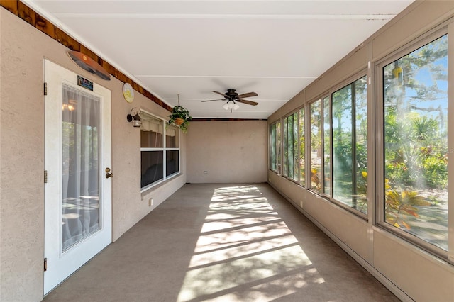 unfurnished sunroom featuring ceiling fan