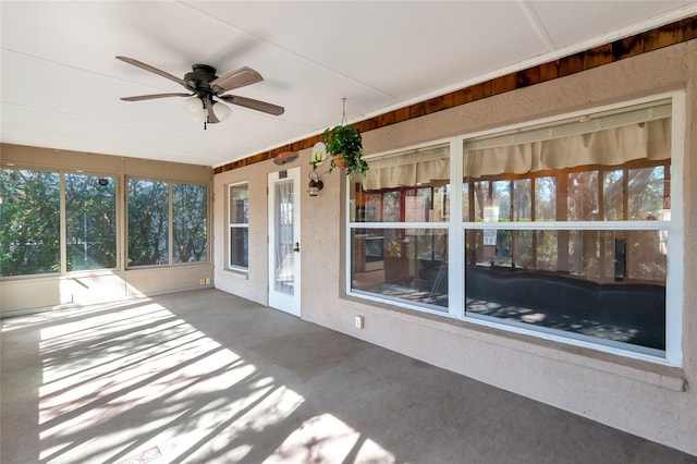 unfurnished sunroom with ceiling fan