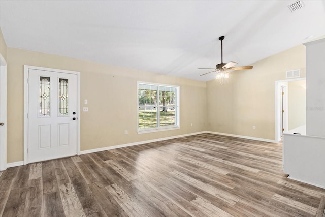 foyer entrance featuring hardwood / wood-style floors, vaulted ceiling, and ceiling fan