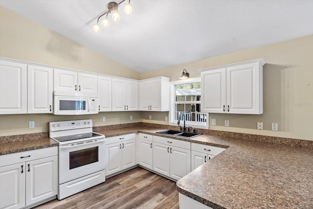 kitchen with sink, white appliances, white cabinetry, dark hardwood / wood-style floors, and vaulted ceiling