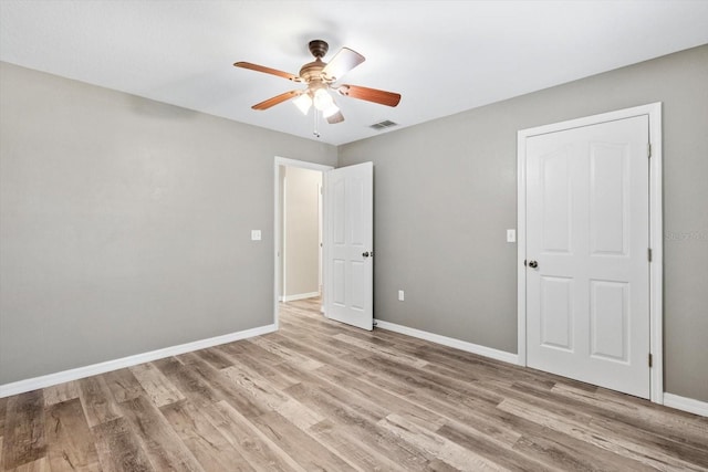 unfurnished bedroom with ceiling fan and light wood-type flooring