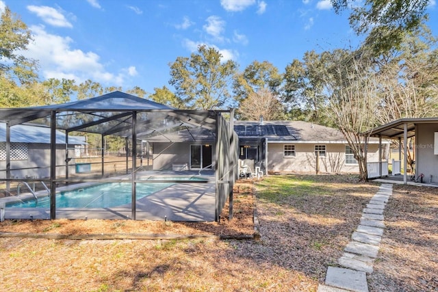 back of house featuring a patio, a lanai, and solar panels