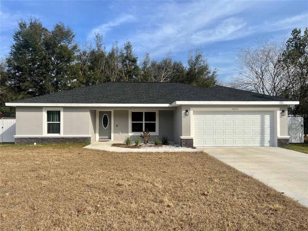 single story home featuring a garage and a front yard