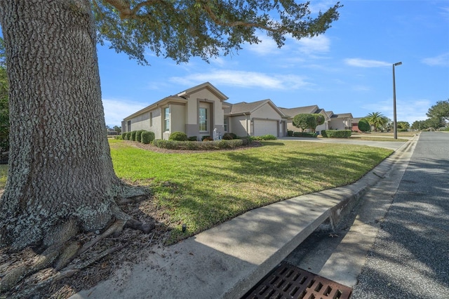 single story home featuring a garage and a front lawn