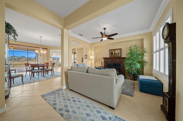 tiled living room featuring ceiling fan with notable chandelier, a wealth of natural light, and ornamental molding