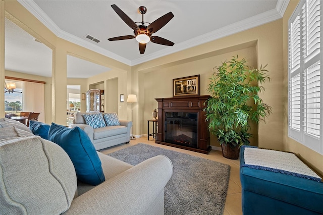 living room with light tile patterned flooring, plenty of natural light, ceiling fan, and crown molding