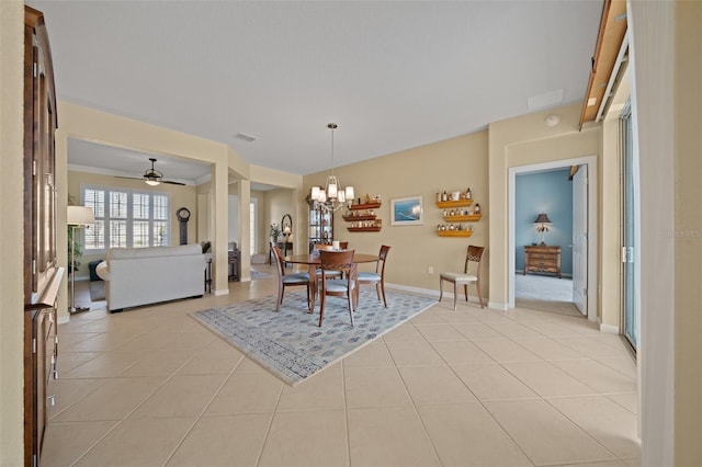 tiled dining area with ceiling fan with notable chandelier