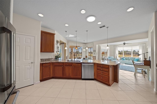 kitchen with hanging light fixtures, light tile patterned floors, appliances with stainless steel finishes, kitchen peninsula, and light stone countertops