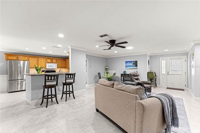 living room with ornamental molding and ceiling fan