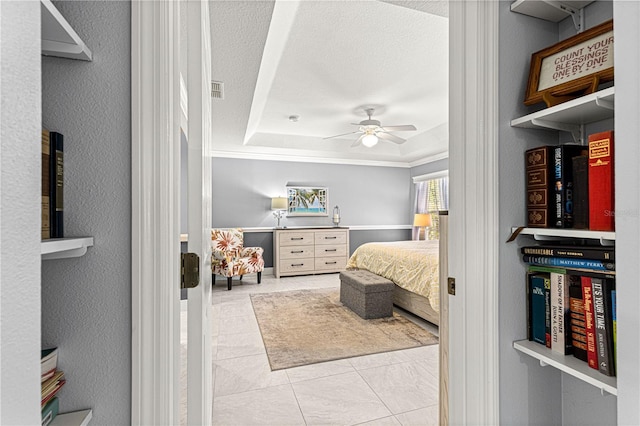 bedroom featuring light tile patterned floors, a tray ceiling, a textured ceiling, and ceiling fan