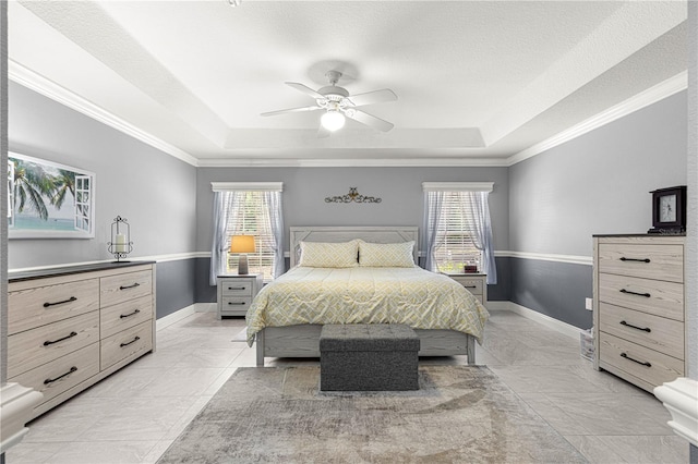 bedroom with ornamental molding, a raised ceiling, and ceiling fan