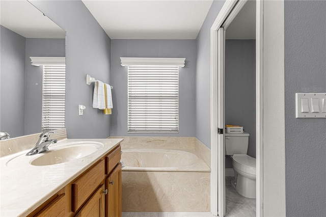 bathroom featuring vanity, a bathtub, and toilet