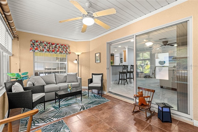 living room featuring ornamental molding, plenty of natural light, and dark tile patterned floors